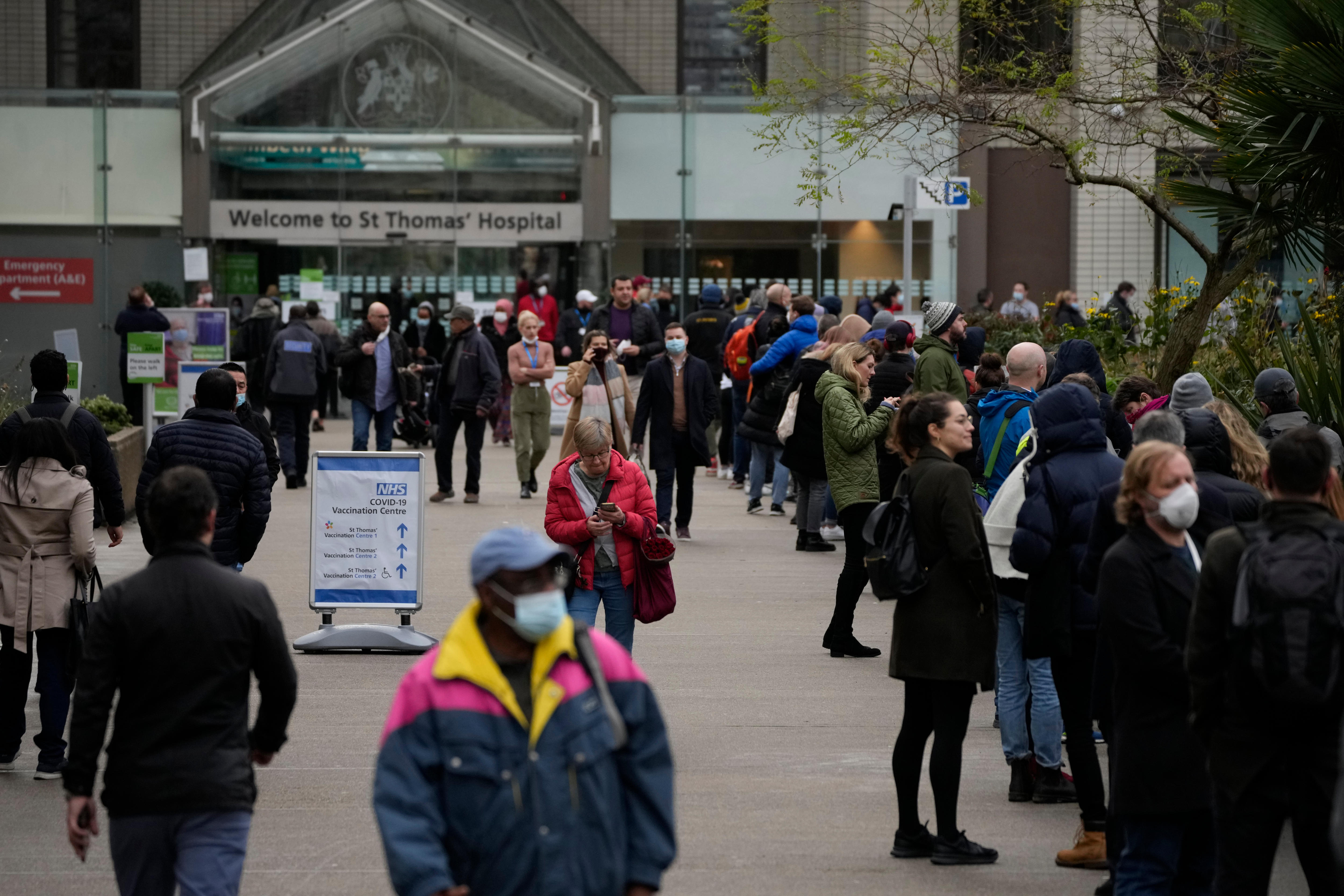 People queue in a line&nbsp;to go for coronavirus booster jabs