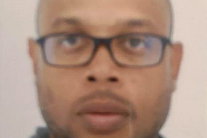 Mickael Harpon stares at the camera blankly. The photo is a close up of his face and appears to have been taken for a passport.