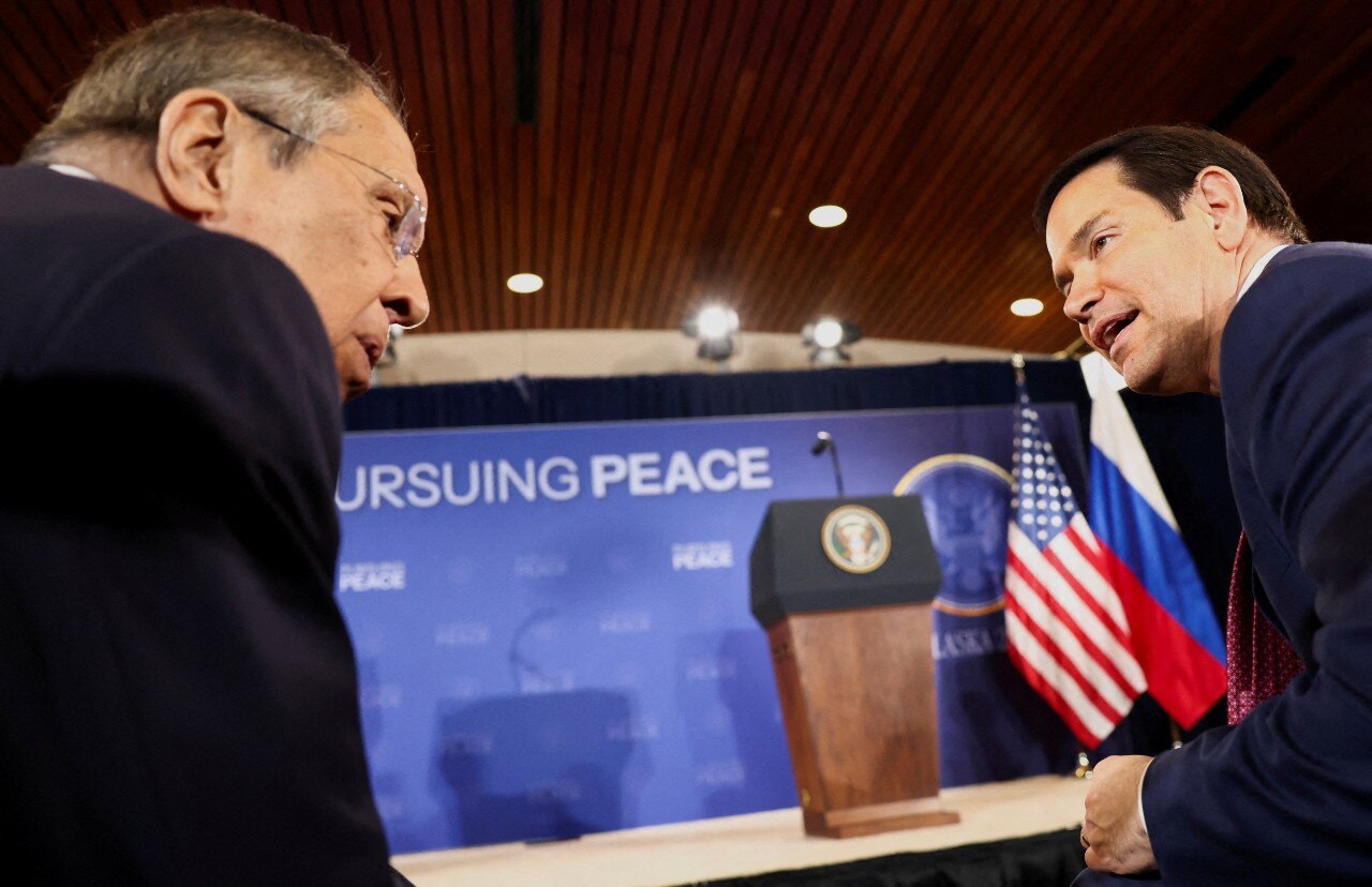 Dois homens de terno conversando.