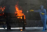 A municipal worker in PPE performs last rites at the cremation of a COVID-19 victim in Mumbai, India.