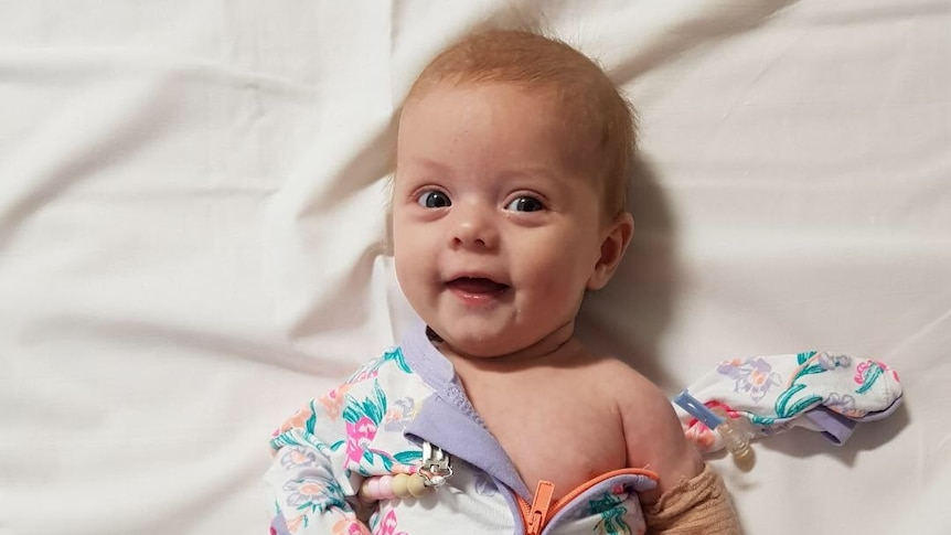 Five-month-old Ivy Marriott lying on a bed.