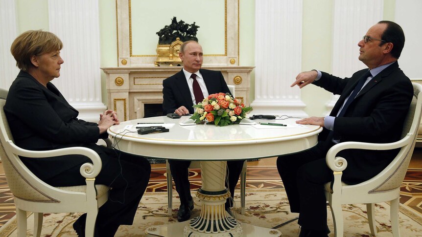 Francois Hollande points during a meeting at the Kremlin in Russia with Vladimir Putin and Angela Merkel