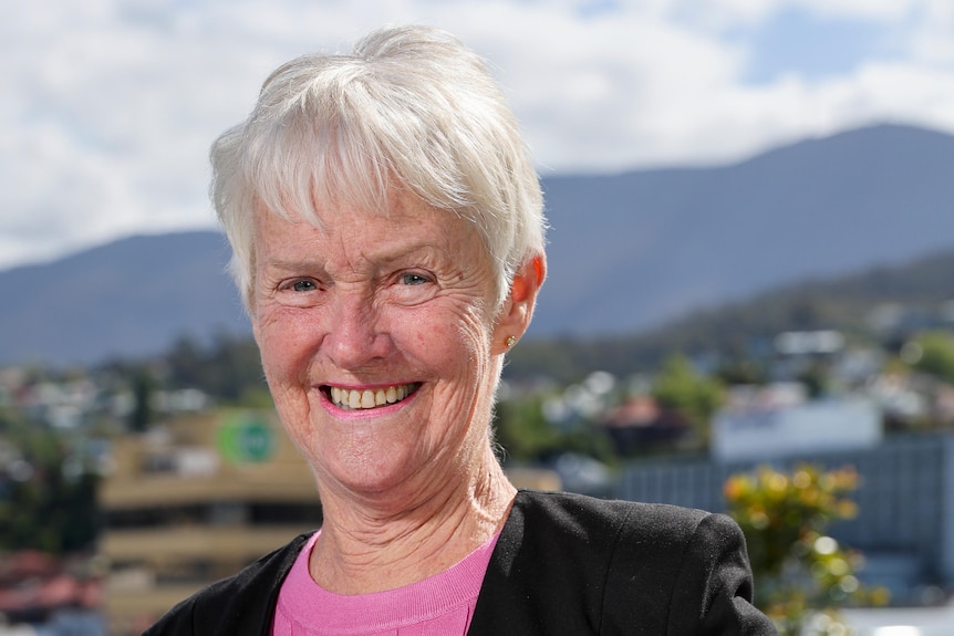 Woman smiling scenic valley with trophy.