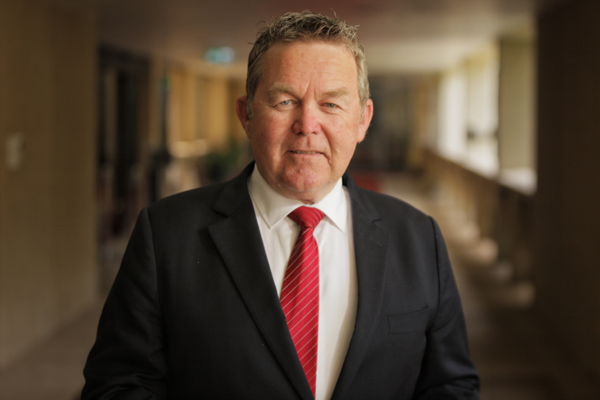 A man wearing a suit with a red tie.