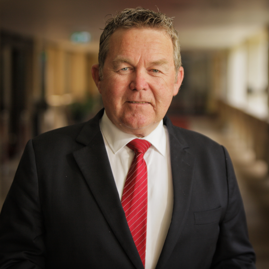 Man wearing a suit with a red tie.