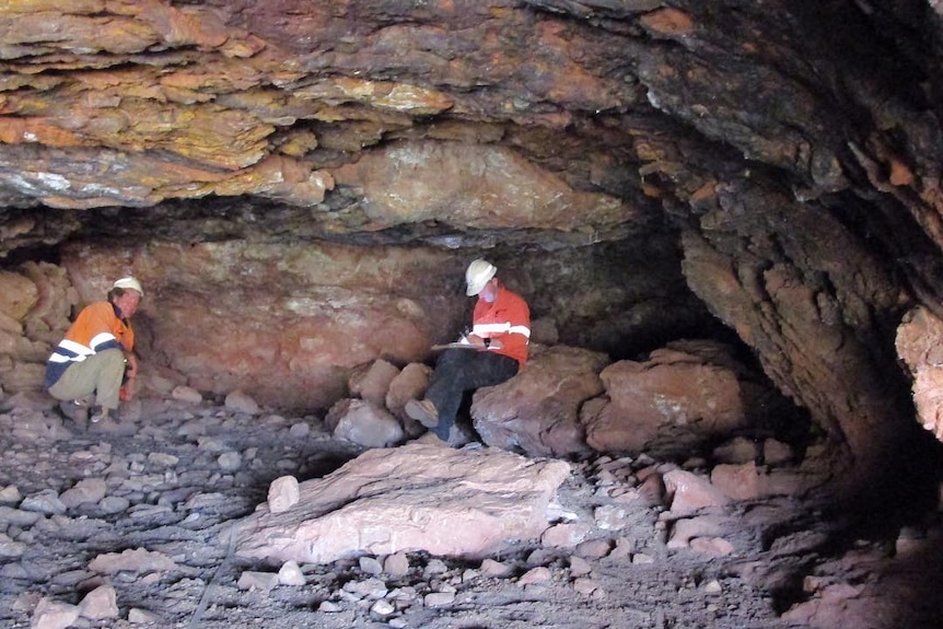 photo of 2 men in a cave