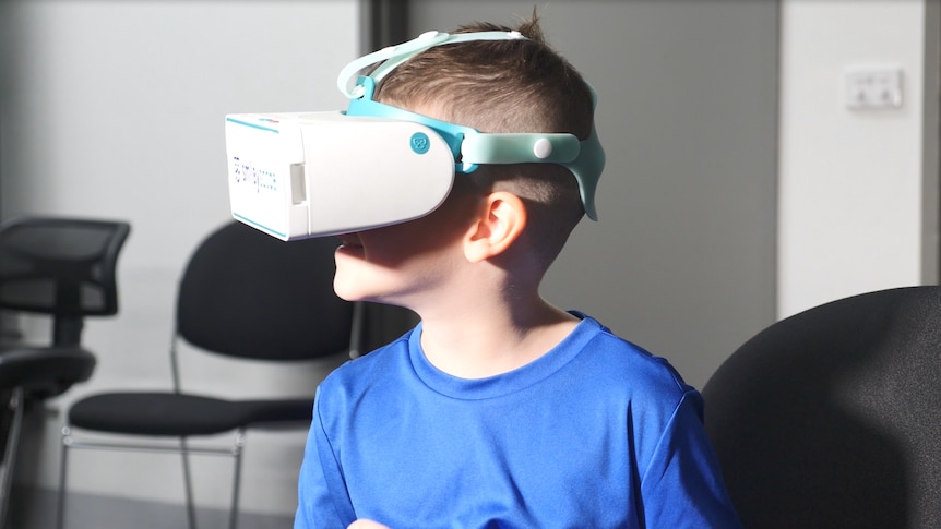 boy with blue tee wears virtual reality headset 