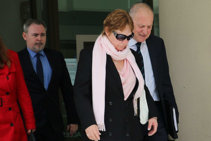 Ms Shewring leaves the Perth Coroner's Court, flanked by lawyer Tom Percy and another man.