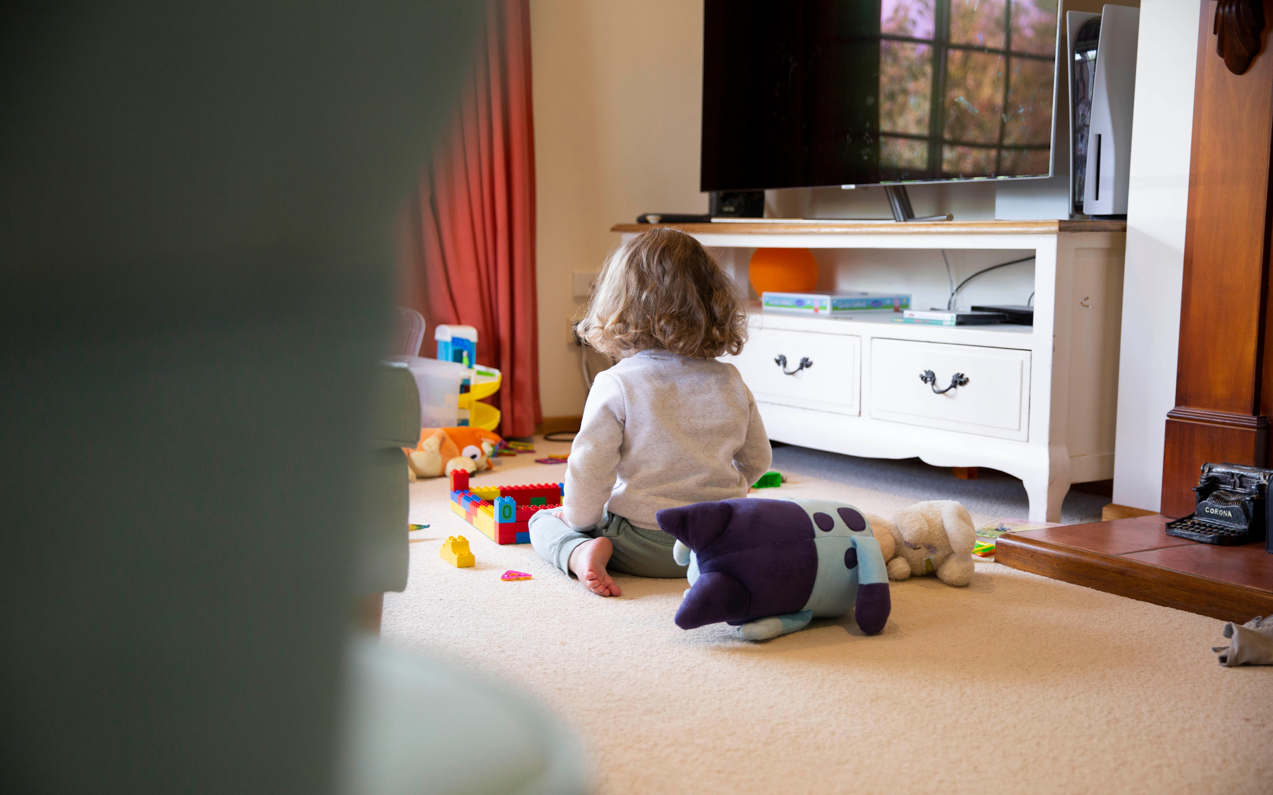 A child sitting on the living room floor.