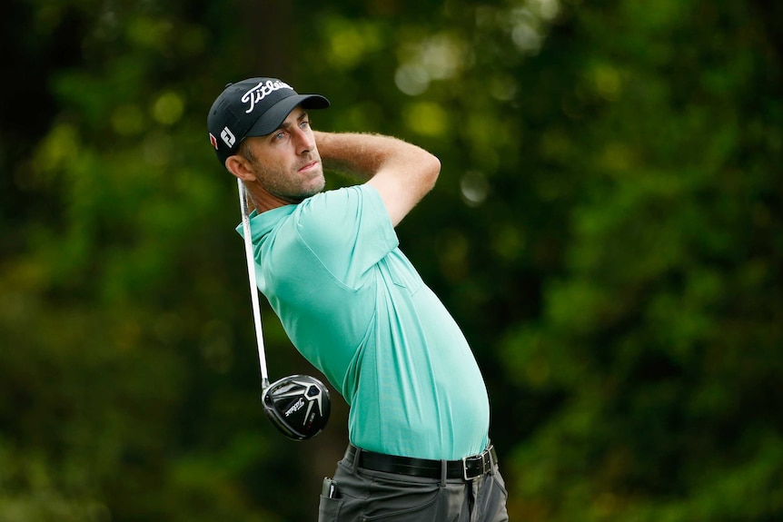 Not giving up ... Geoff Ogilvy hits his tee shot on the second hole