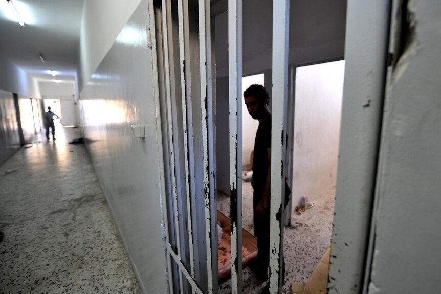 A rebel walks down the corridor of the former Libyan secret police headquarters in Tripoli.