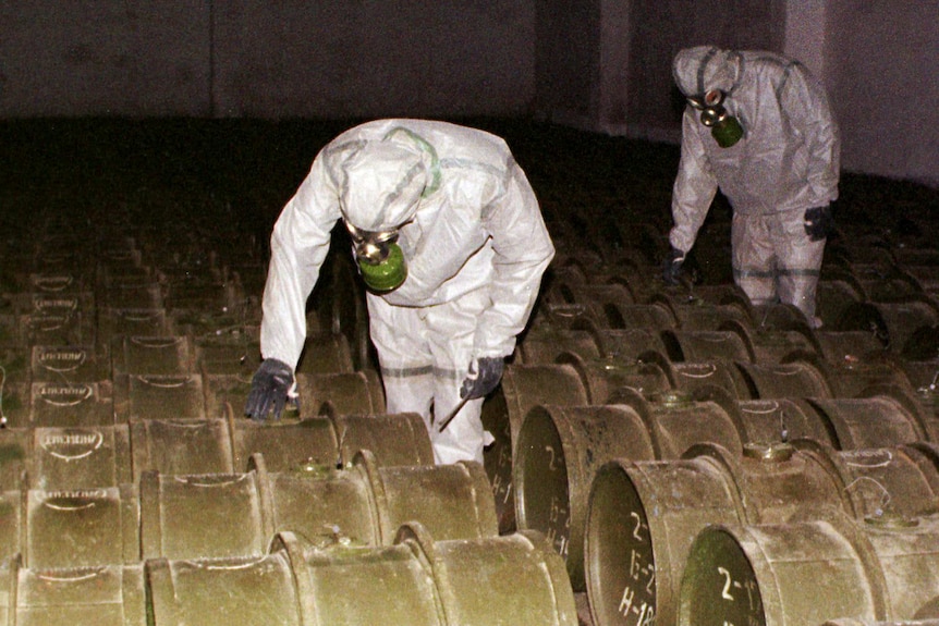 Russian military officers insoecting barrels of chemical weapons.