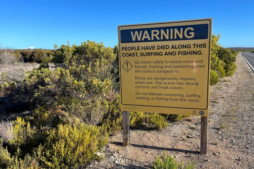 A warning sign about people dying on the coast