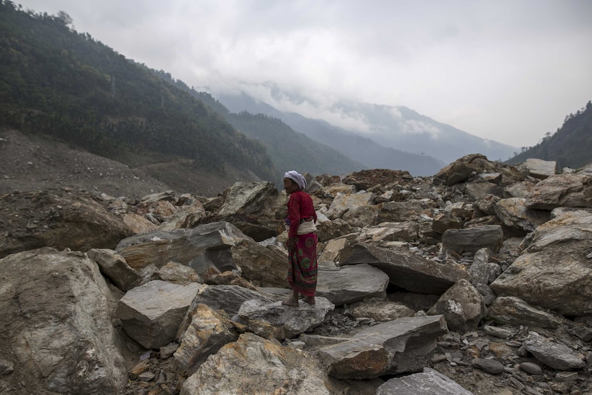 A Nepalese woman stands on a landslide area in Jure village
