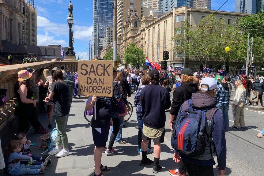 Protesters holding signs demonstrate in a city street