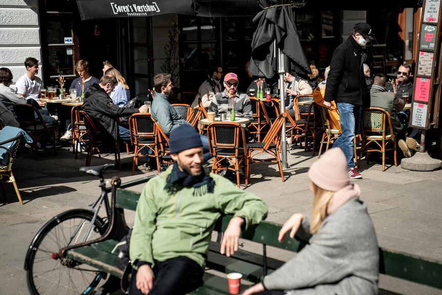 People sit at an outdoor cafe in Copenhagen. 