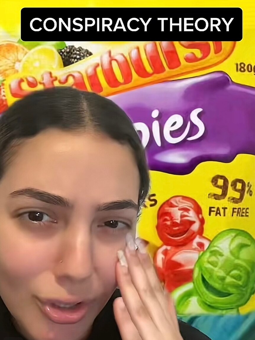 A woman appears sad infront of a Starburst lollies packet. 