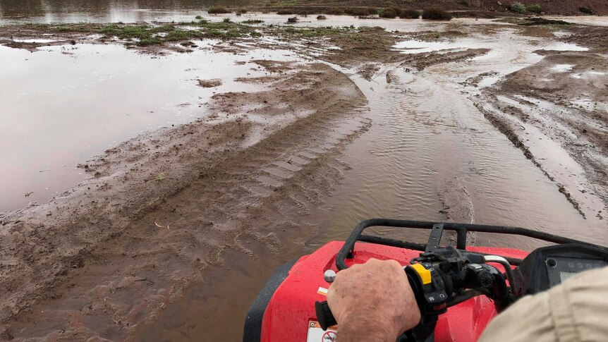 Flooded fields from the point of view of a man riding a quad bike