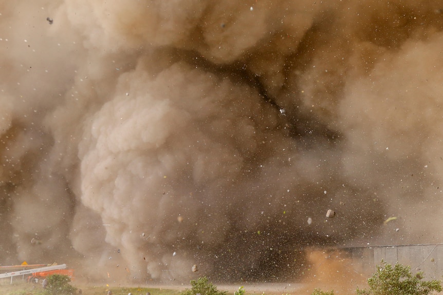 A big brown cloud of debris and sand is pictured.