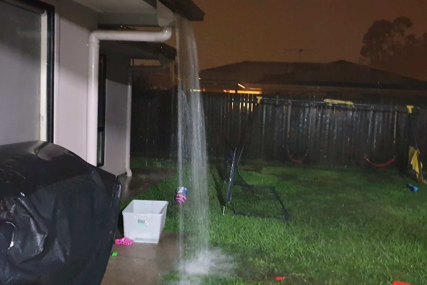 Water pours from the gutter of a home in Caboolture.