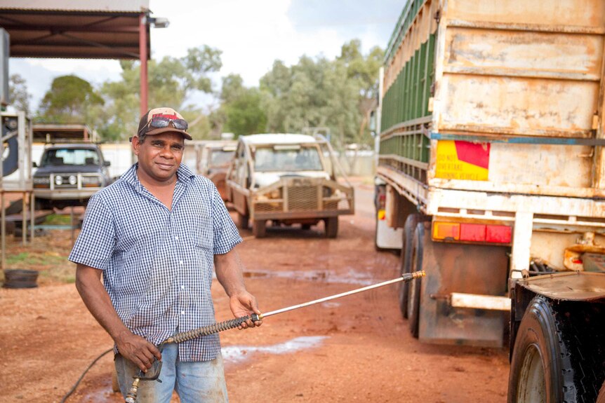 Harry McCormack at Blackstone in the Ngaanyatjarra Lands, washing down the camel trucks.