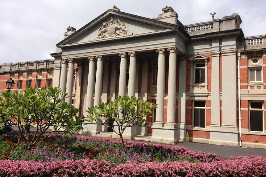 A wide shot of the Supreme Court in Perth with a flower bed in the foreground.