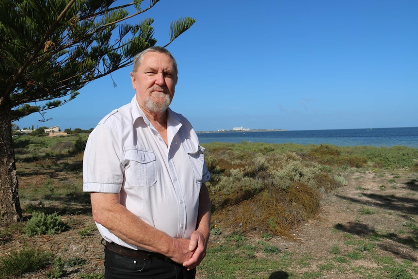 Allan Suter, former mayor of Ceduna, poses for a photo by the beach.