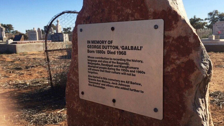 A plaque on a red rock reading: In memory of George Dutton, 'Galbali'. Born 1800s Died 1968.