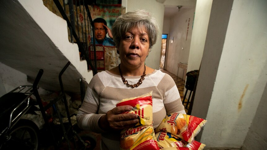 A Venezuelan woman holding bags of corn meal