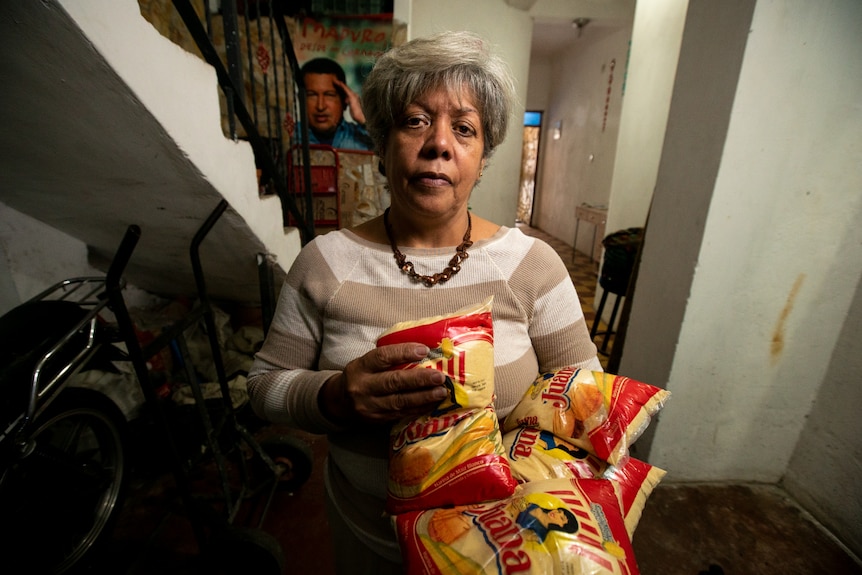 A Venezuelan woman holding bags of corn meal
