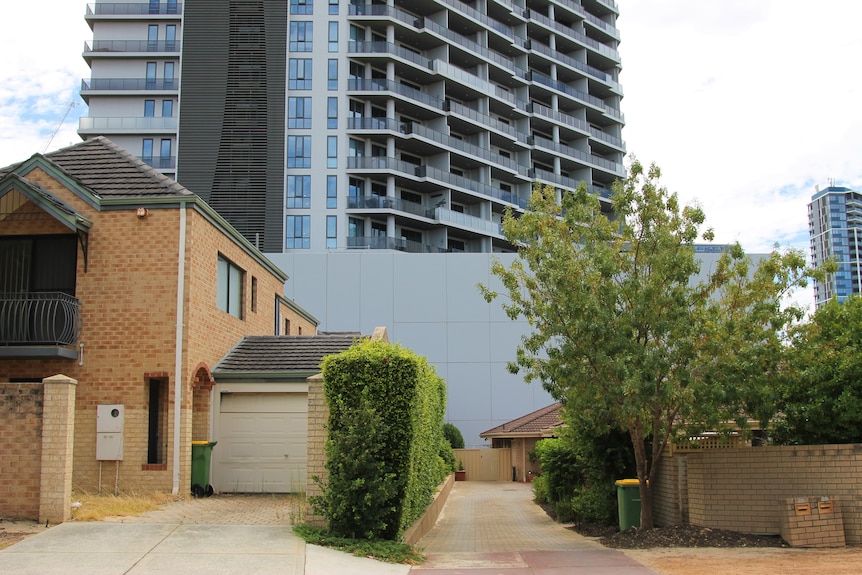 A high-rise building in the backdrop of smaller density housing