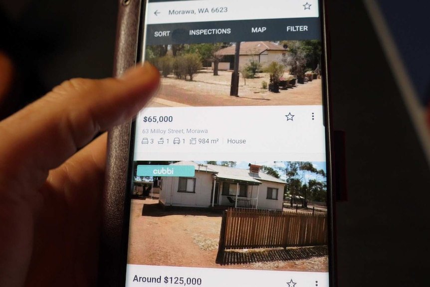 A thumb scrolls through a real estate listing of Morawa house prices on a phone.