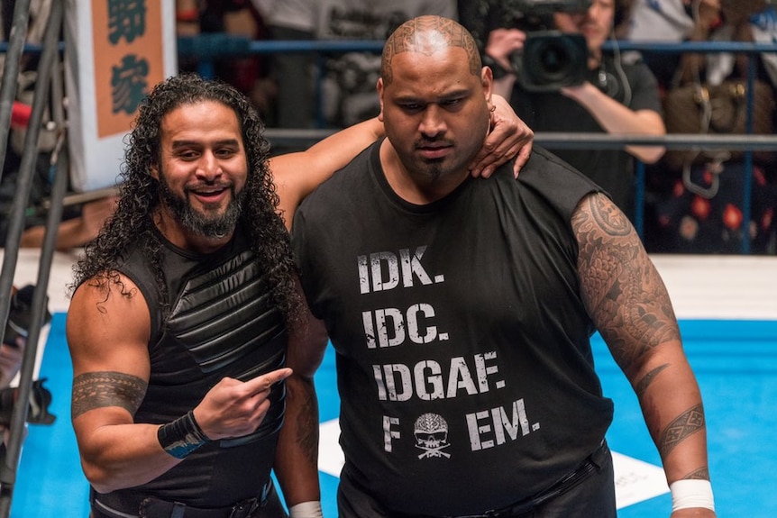 Tama Tonga, left, has one arm around Toks Fale in a wrestling ring.