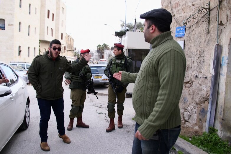 Issa Amro argues with soldiers.