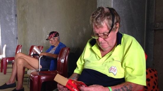 Brian Spence reads a book in the evacuation centre