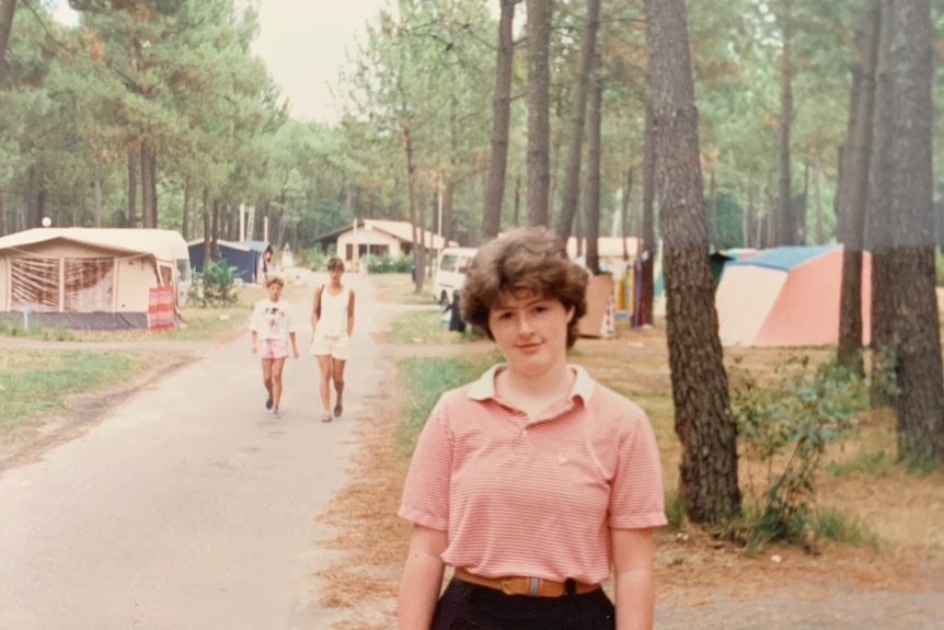 A young woman stands in a camp ground