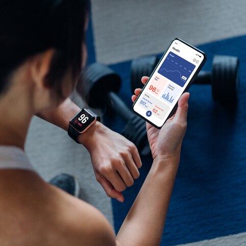 Woman using an exercise tracking app on smartphone to monitor her training progress