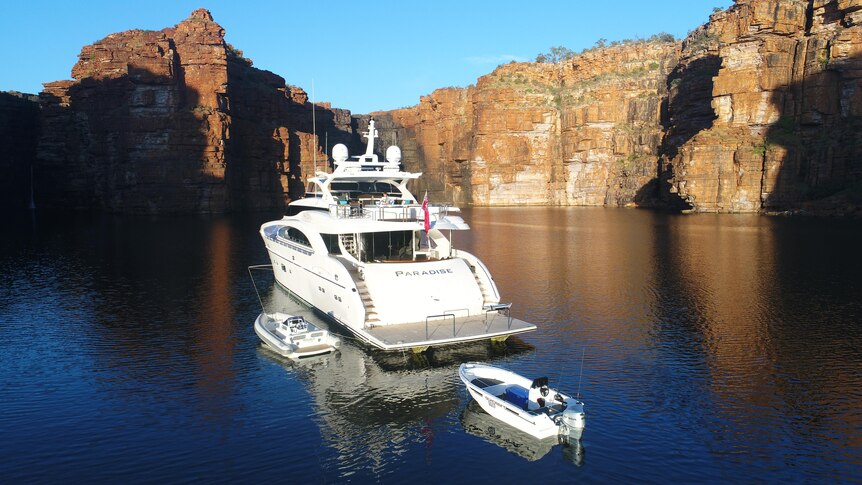 A super yacht at the base of a Kimberley waterfall.