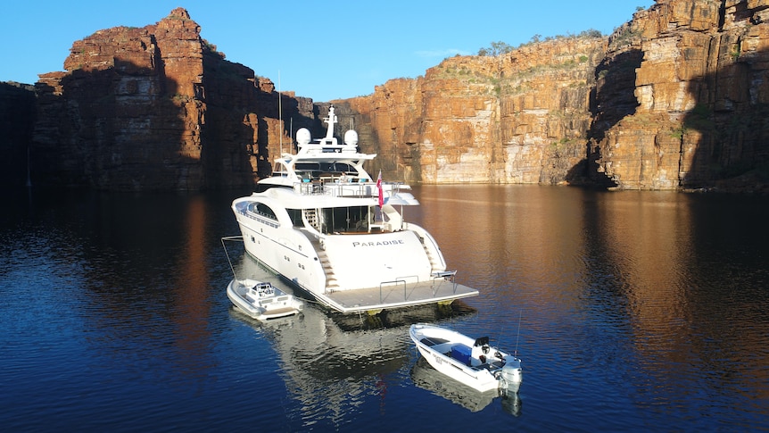 A super yacht at the base of a Kimberley waterfall.