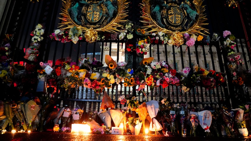 Tributes and candles are left outside the gates of Buckingham Palace.
