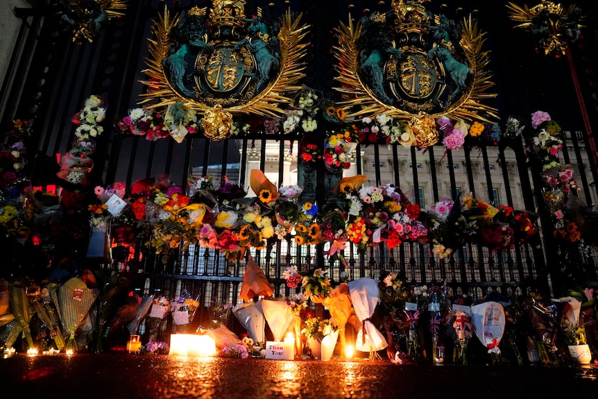 Tributes and candles are left outside the gates of Buckingham Palace.