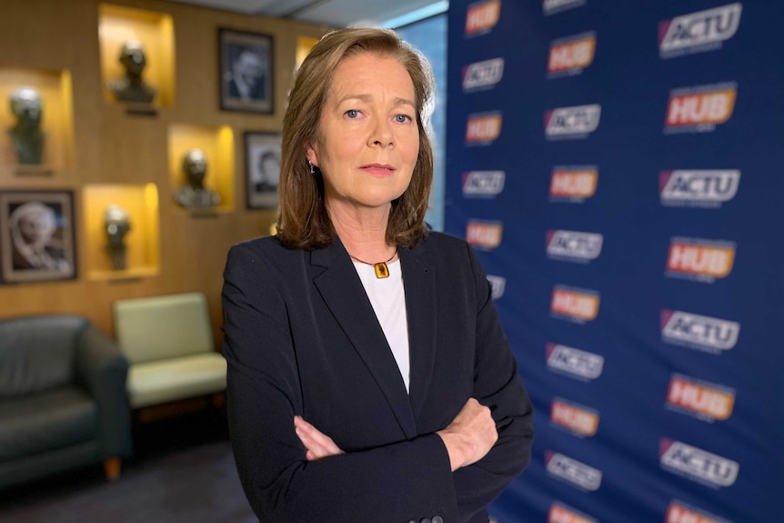 Michele O'Neil stands in the ACTU Melbourne office. She is wearing a navy suit jacket and white shirt.