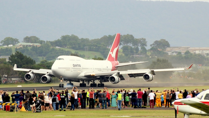 A crowd watches the Qantas 747 VH-OJA land at Albion Park airport.