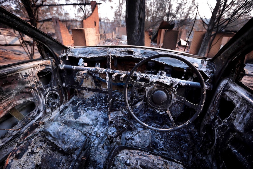 The burnt-out remains of a car and houses