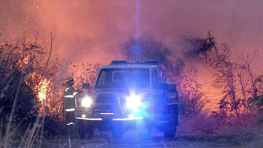 Firefighter and truck at night scrub fire
