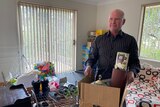 Man with a box of items as he prepares to move out of his unit