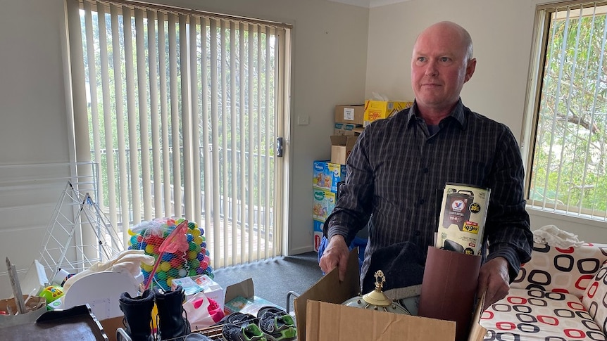 Man with a box of items as he prepares to move out of his unit