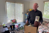 Man with a box of items as he prepares to move out of his unit