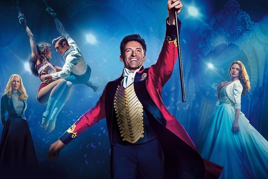 The Greatest Showman poster featuring Hugh Jackman holding up a cane in a circus tent.