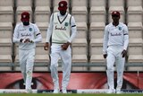 Five male West Indian cricketers walk onto the field during a Test against England.